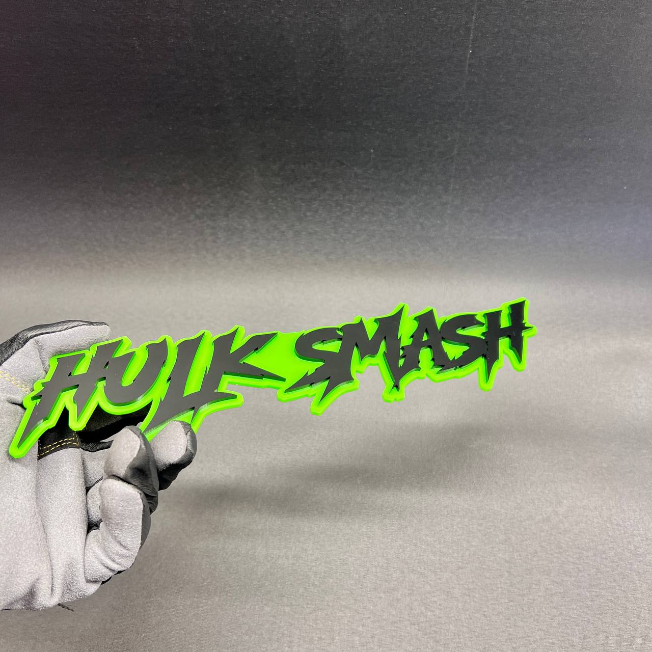 Green HULK SMASH text car badge with black raised lettering