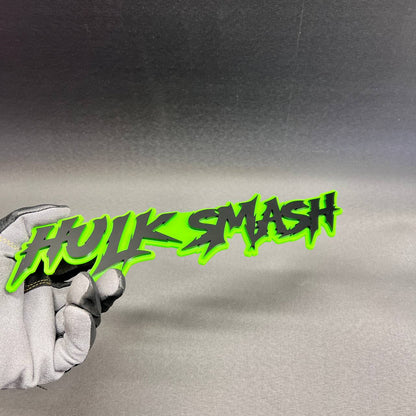 Green HULK SMASH text car badge with black raised lettering