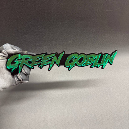 Green Goblin custom car badge featuring metallic green lettering with glossy black backing, Marvel villain themed fender emblem for Ford Mustang and Shelby builds.