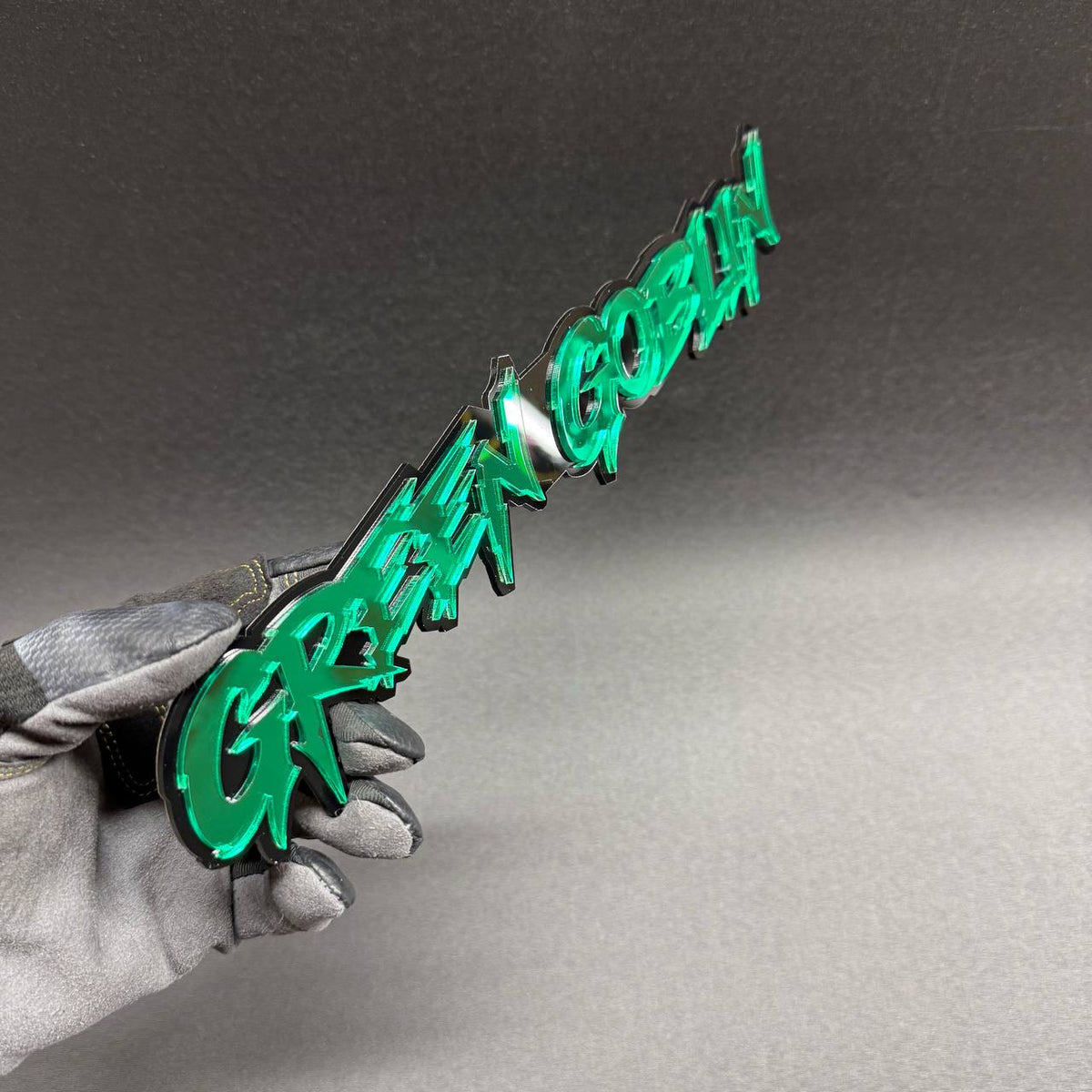Green Goblin Spider-Man villain inspired car text badge in green and black, decorative aftermarket emblem for Chevrolet Silverado and GMC Sierra trucks.