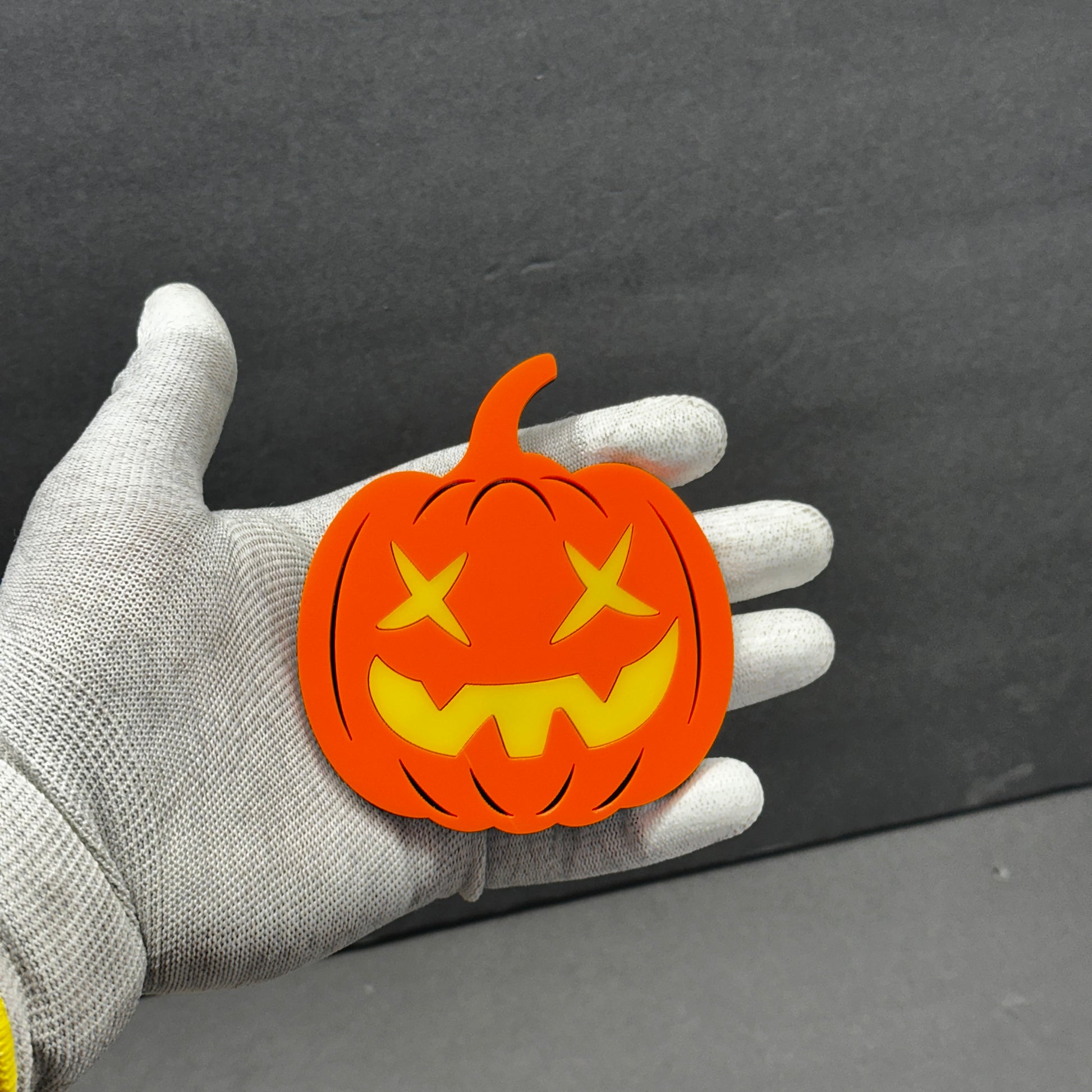 Bright orange Halloween vehicle badge with layered yellow pumpkin face