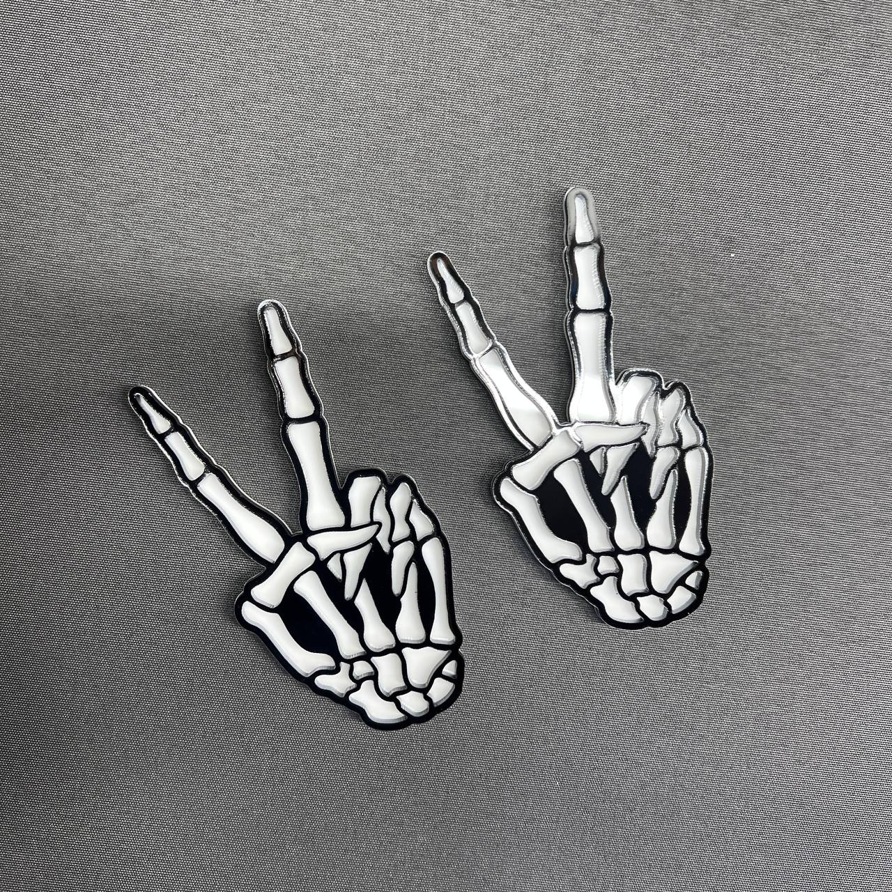 Bone hand car badge emblem with bold black and white design.