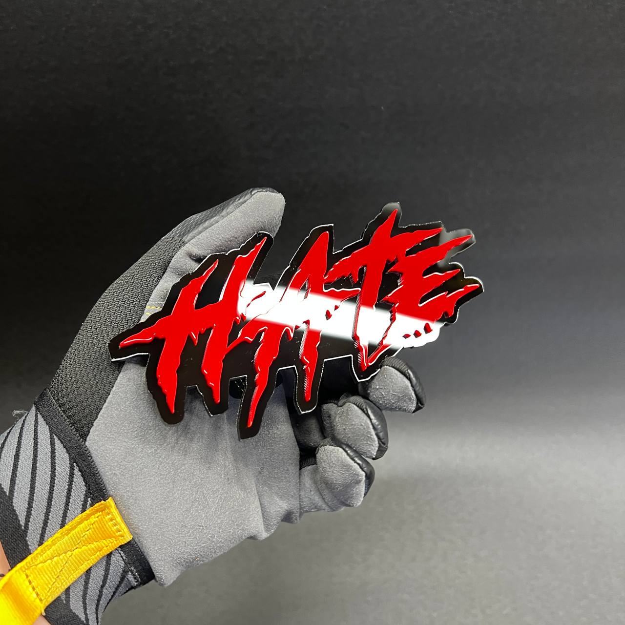 HATE text car badge with jagged graffiti style lettering and glossy finish.