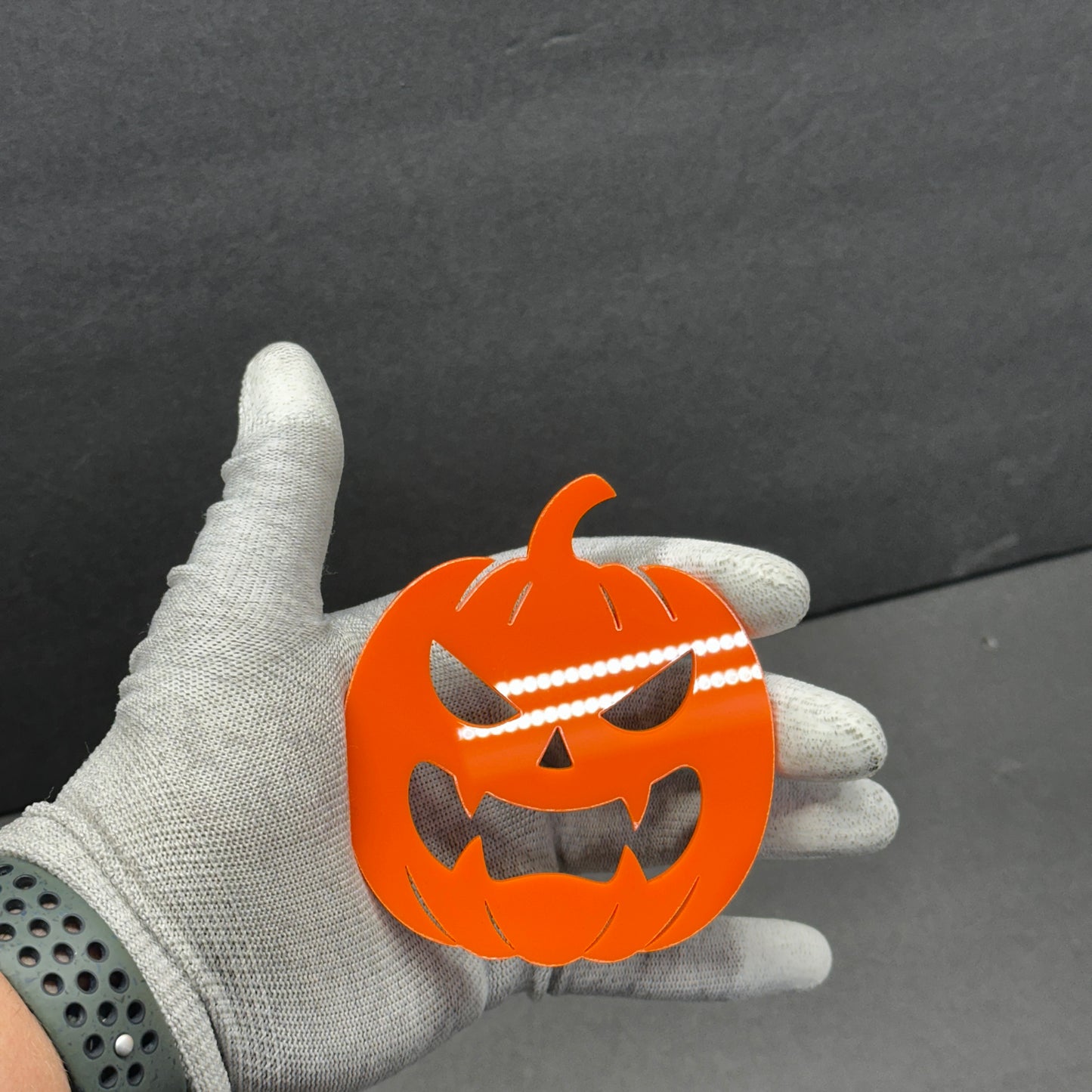 Scary jack-o-lantern vehicle badge in bright orange finish