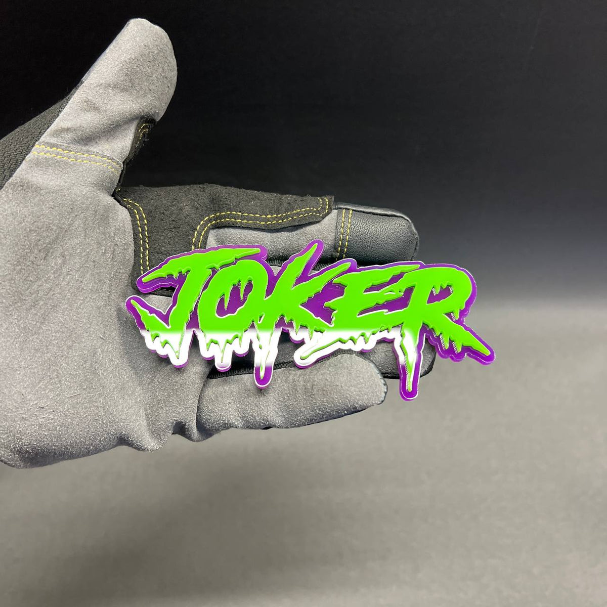 Custom JOKER text automotive emblem in bright green with purple background