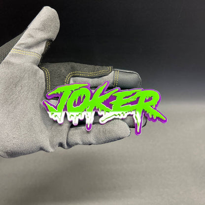 Custom JOKER text automotive emblem in bright green with purple background