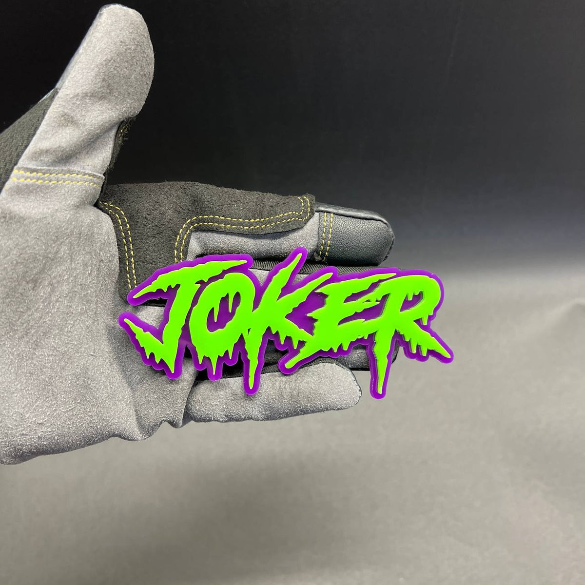 Green JOKER lettering automotive badge with purple outline and 3M adhesive backing