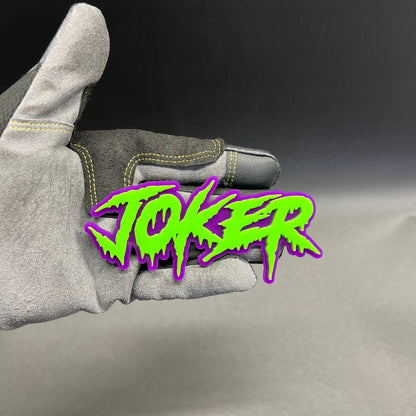 Green JOKER lettering automotive badge with purple outline and 3M adhesive backing