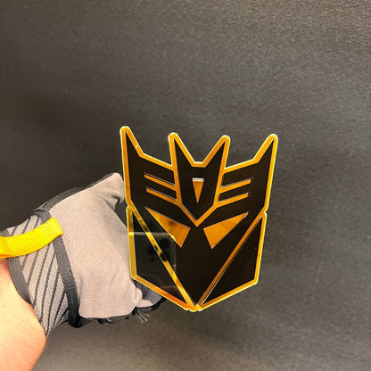 Decepticon inspired hitch cover badge with layered black and gold design.