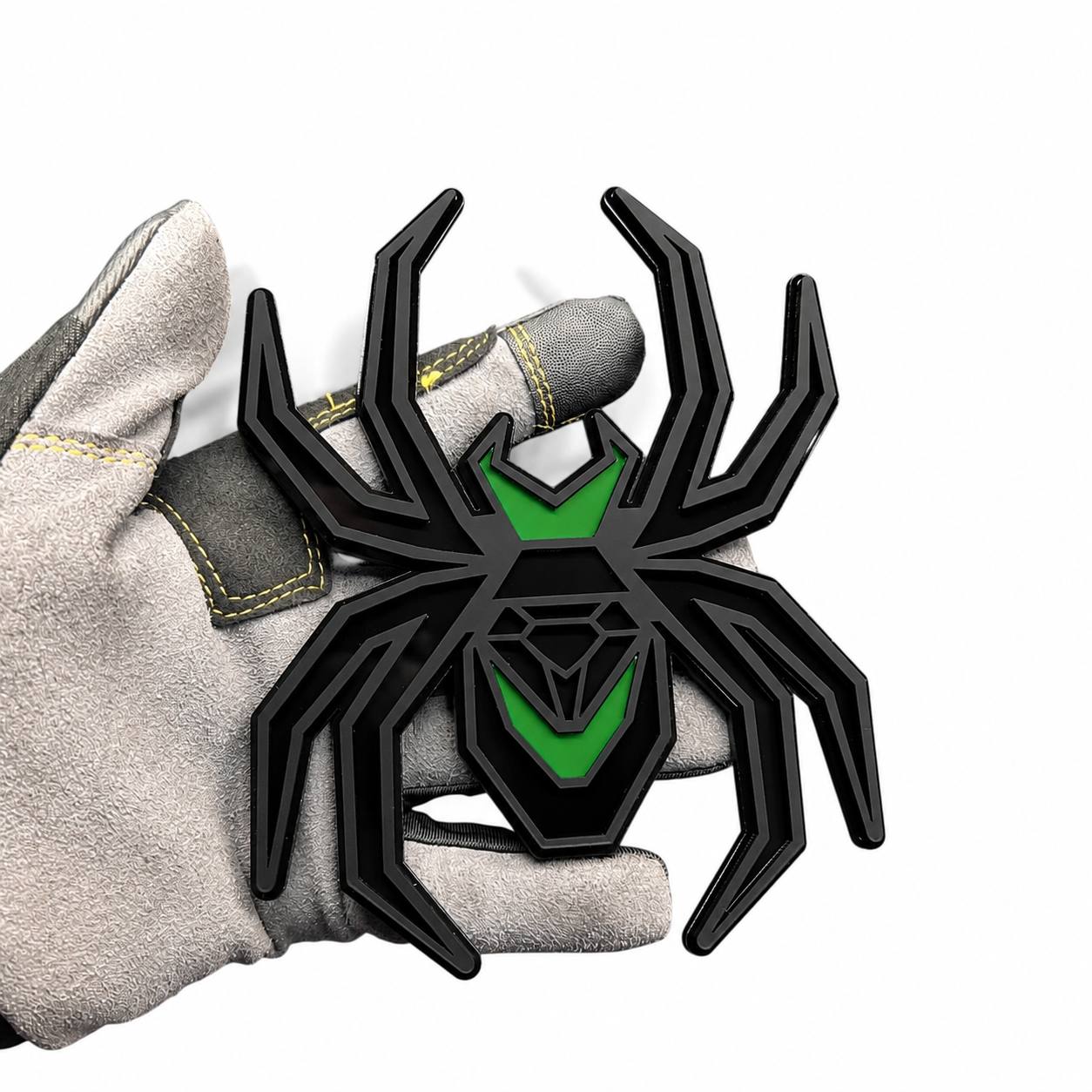 Matte black and green Black Widow spider hitch cover with layered custom automotive design.