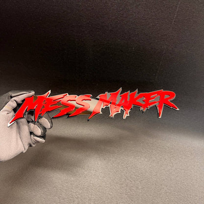 Red MESS MAKER automotive emblem with sharp graffiti style lettering