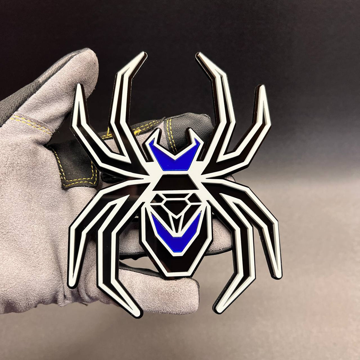Gray on black Black Widow car badge with mirror blue accents for custom fender styling.