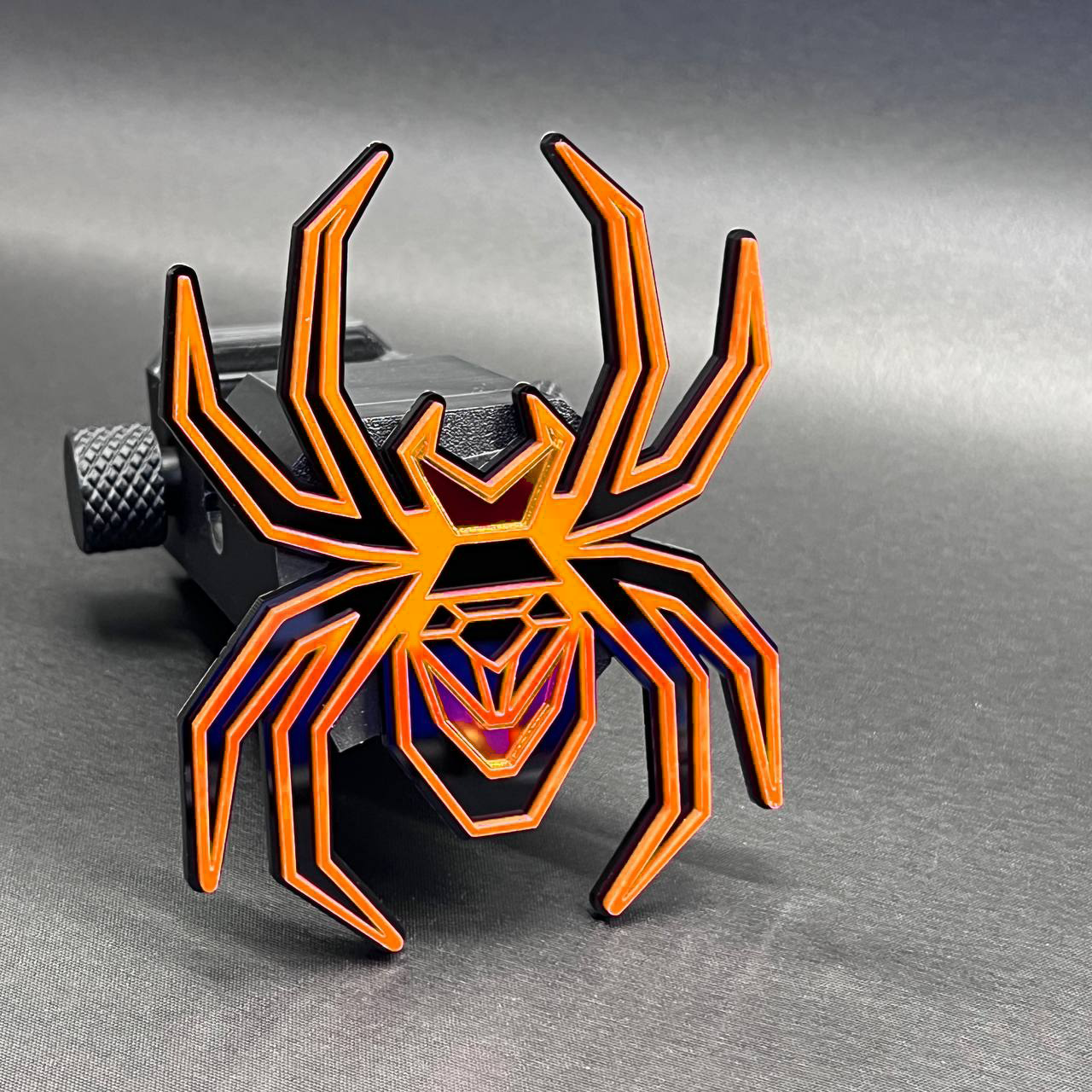 Red mirror Black Widow spider hitch cover with durable automotive finish.