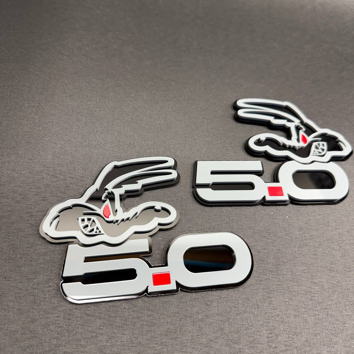 Ford Coyote V8 custom car emblem featuring stylized 5.0 engine lettering, red accent and gray-black finish.