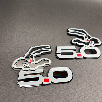 Ford Coyote V8 custom car emblem featuring stylized 5.0 engine lettering, red accent and gray-black finish.