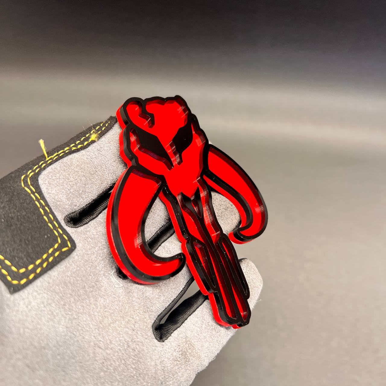 Red Mythosaur car badge with black outline