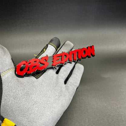 Custom OBS Edition automotive emblem in red with black outline for vehicle fender or tailgate.