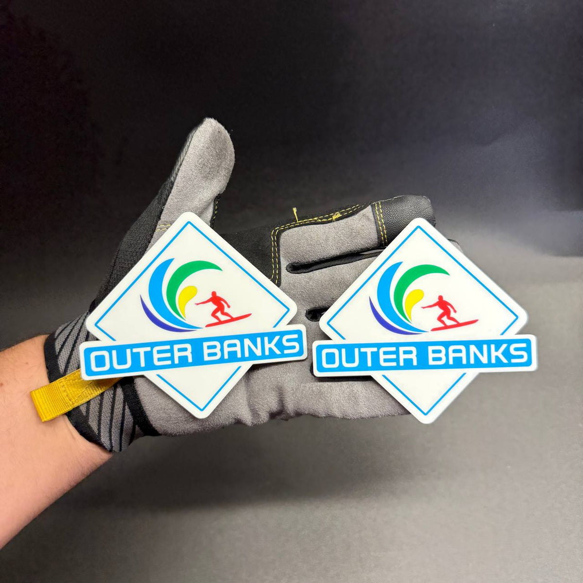UV printed Outer Banks side badge with blue green yellow wave and red surfer