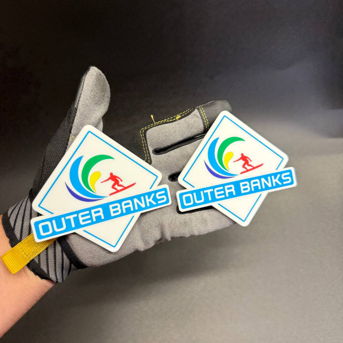 UV printed Outer Banks side badge with blue green yellow wave and red surfer