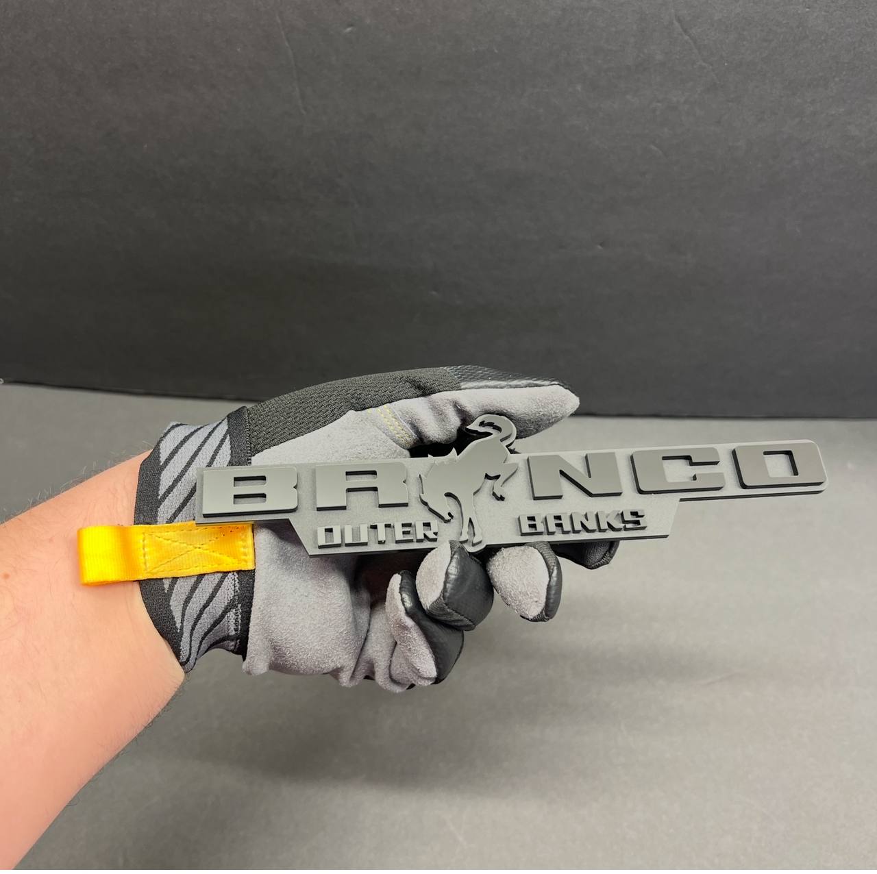 Gray BRONCO Outer Banks car badge fender emblem with raised lettering and horse center design