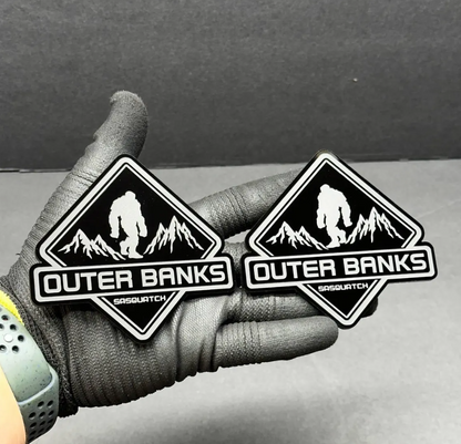 Custom Sasquatch mountain car emblem with black engraved details and brushed metal look