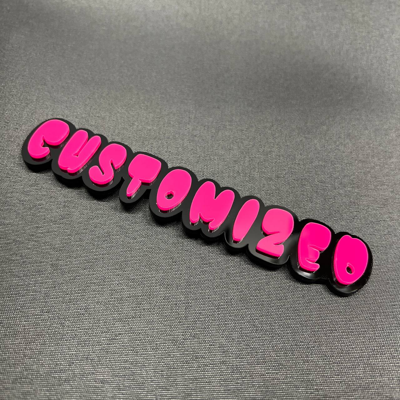 Pink and black custom nameplate badge in graffiti lettering style