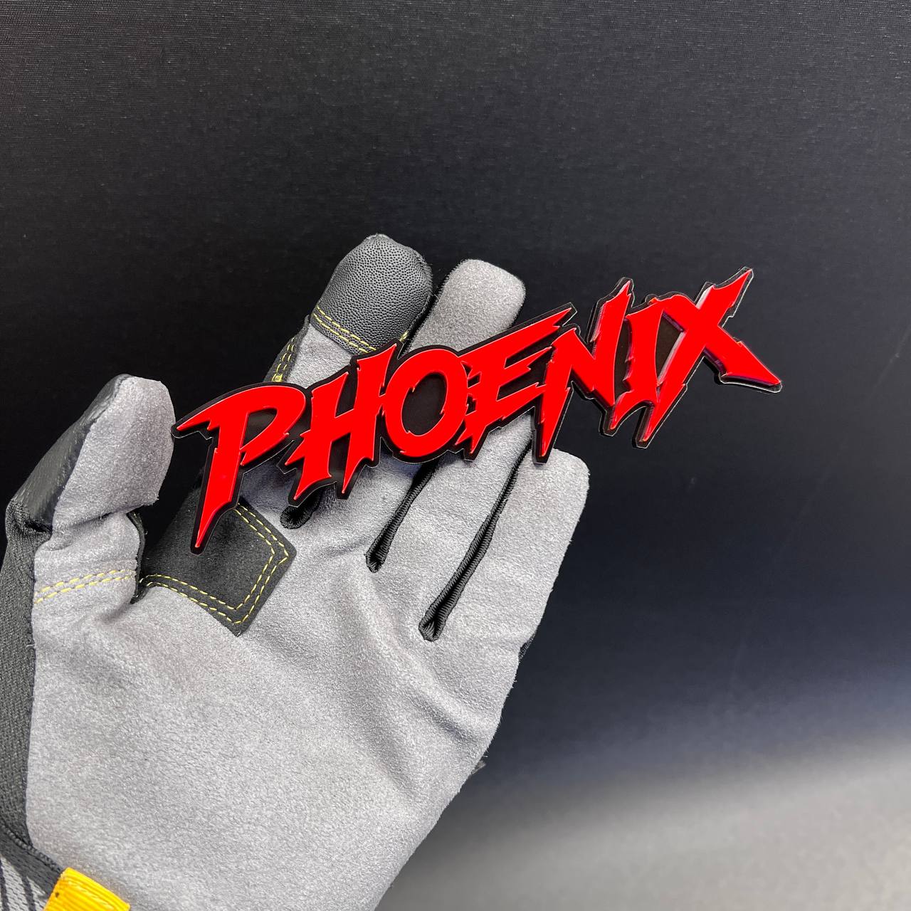 Gloss red Phoenix automotive lettering emblem with black background