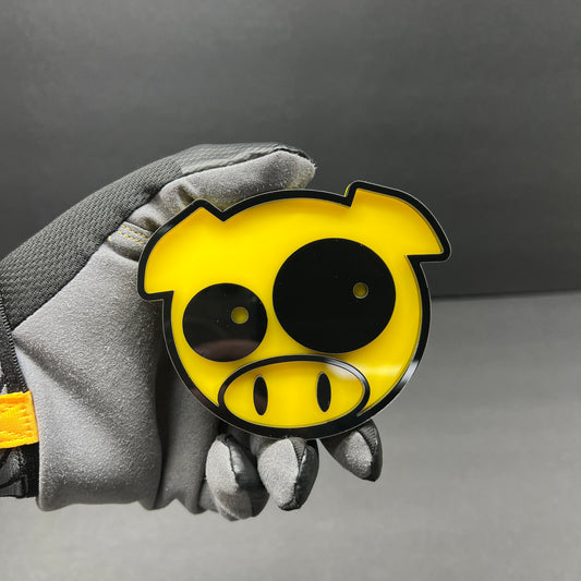 Yellow and black pig car badge fender emblem with cartoon pig face design