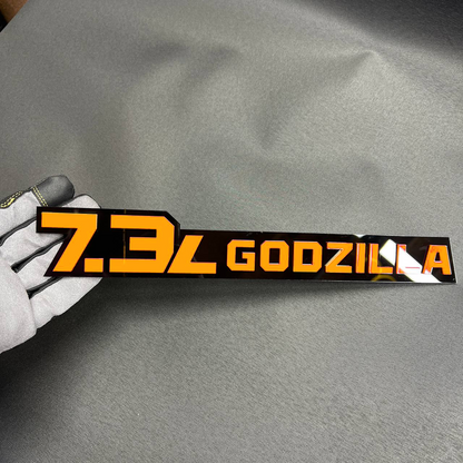 Pink 7.3L Godzilla truck emblem with black base for performance-style fender or tailgate install.