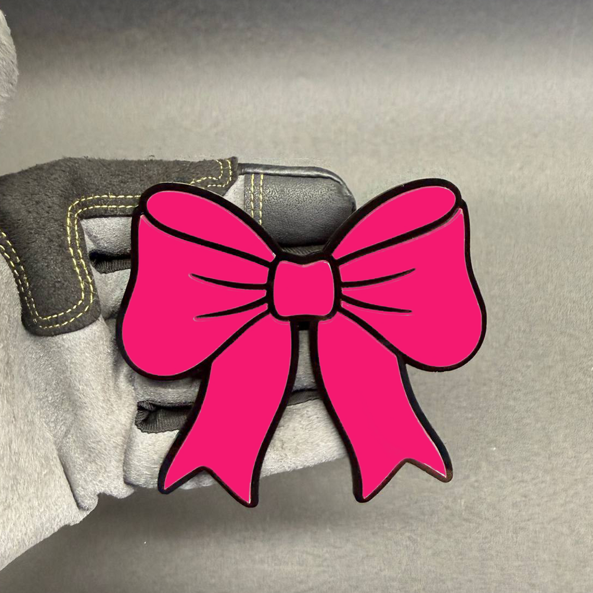 Hot pink bowtie car badge with black outline, cute decorative automotive emblem