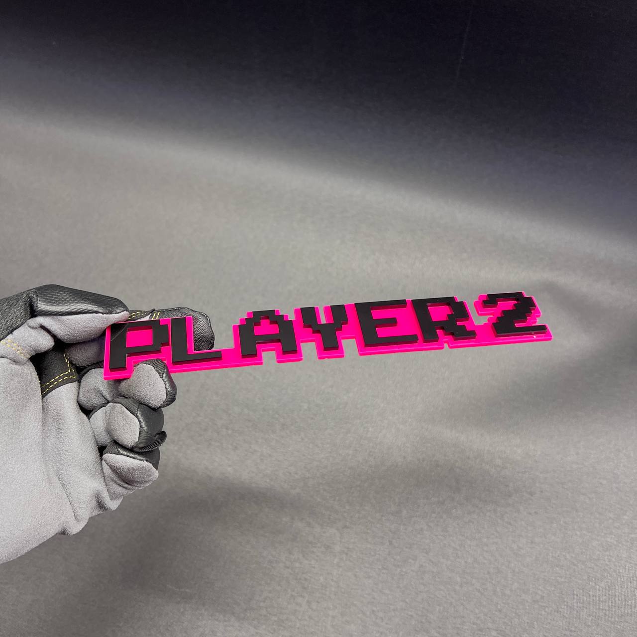 Pink and black PLAYER 2 car emblem for fender, tailgate, or trunk decor.