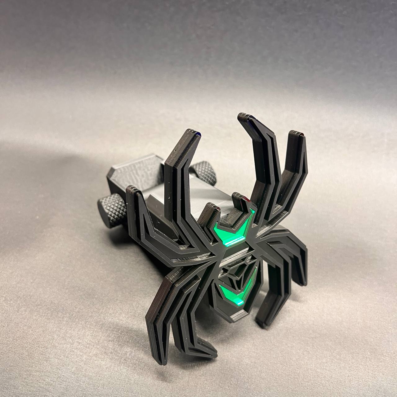 Custom black and green spider trailer hitch receiver cover with detailed layered construction.