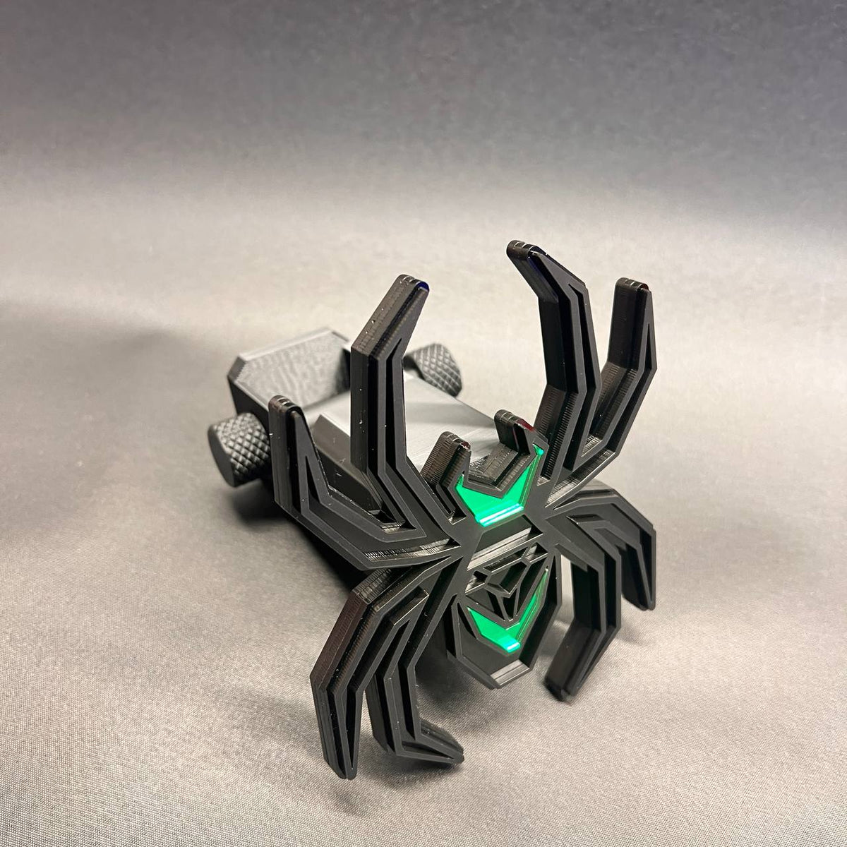 Custom black and green spider trailer hitch receiver cover with detailed layered construction.