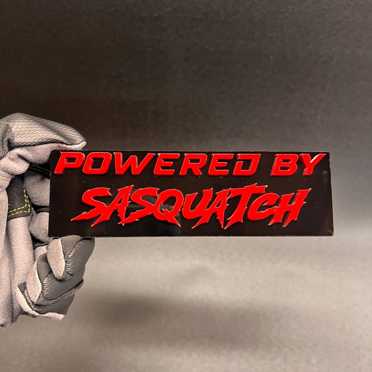 Red Powered by Sasquatch exterior badge on glossy black backing