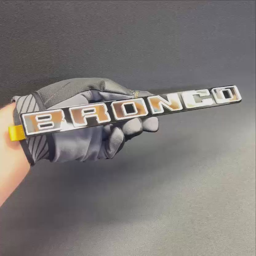Custom BRONCO letter badge with raised silver lettering on black acrylic base