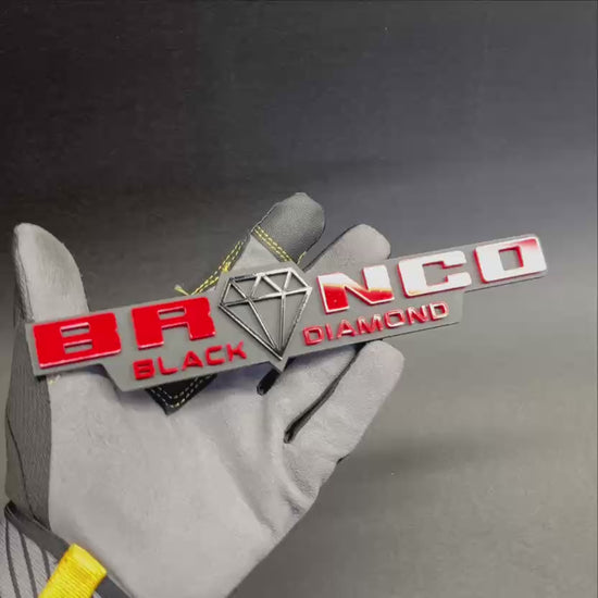 Custom Bronco Black Diamond text badge with matte black base and red letters.