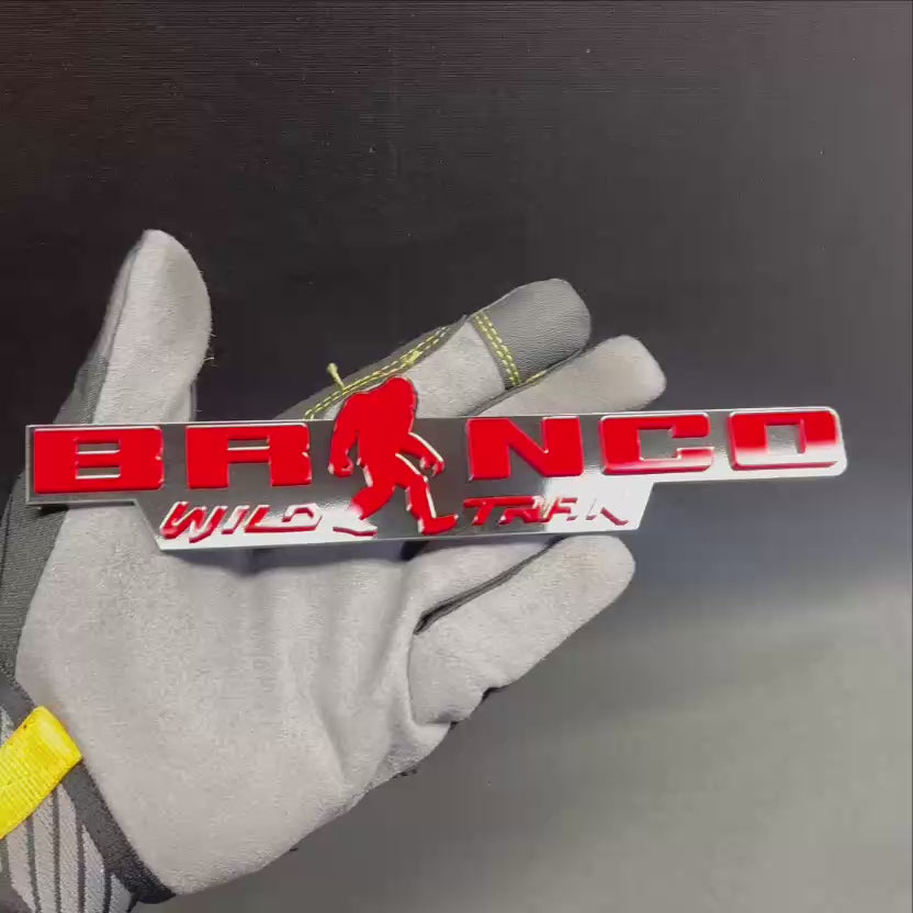 Bronco Wild Trak Sasquatch fender emblem in red on a black background