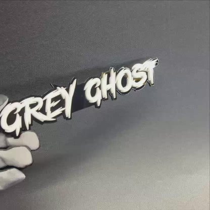 Handmade Grey Ghost vehicle badge with sharp racing-style lettering for hood, fender, trunk, or rear emblem use.