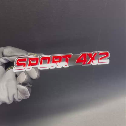 SPORT 4x2 automotive text badge featuring bright red letters on a black background.