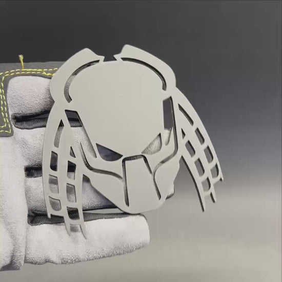 Laser cut Predator mask vehicle emblem shown in matte gray finish