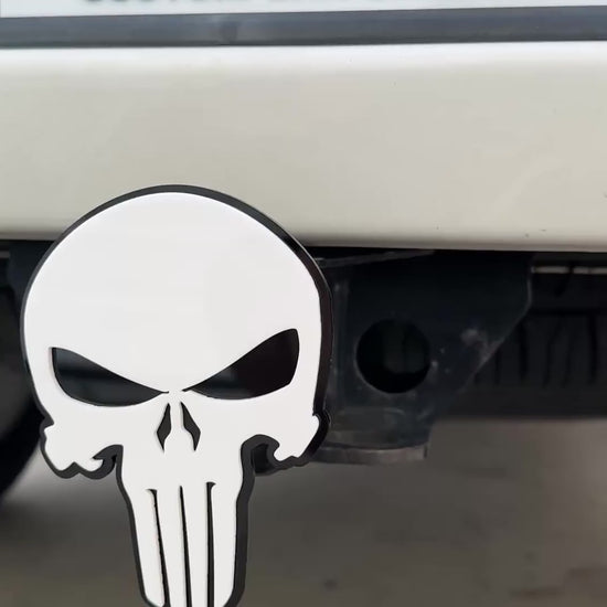 White and black Punisher skull hitch cover emblem mounted on truck receiver