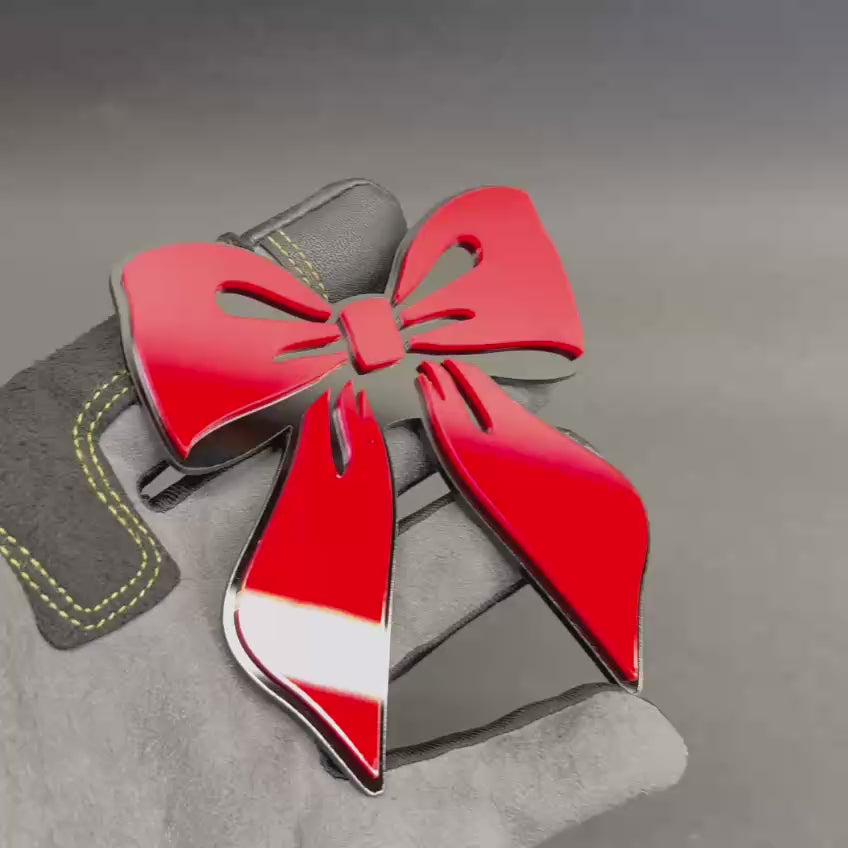 Girly pink bow car accessory with black border, decorative emblem for personalized feminine car styling.
