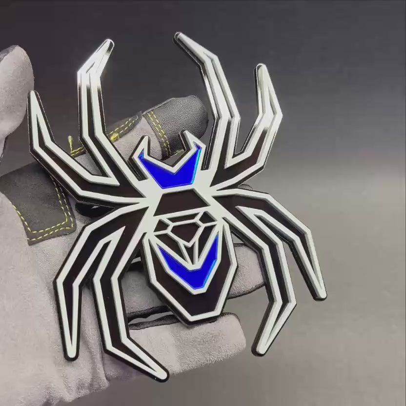 Custom Black Widow spider fender emblem in gray and black with reflective mirror blue details.