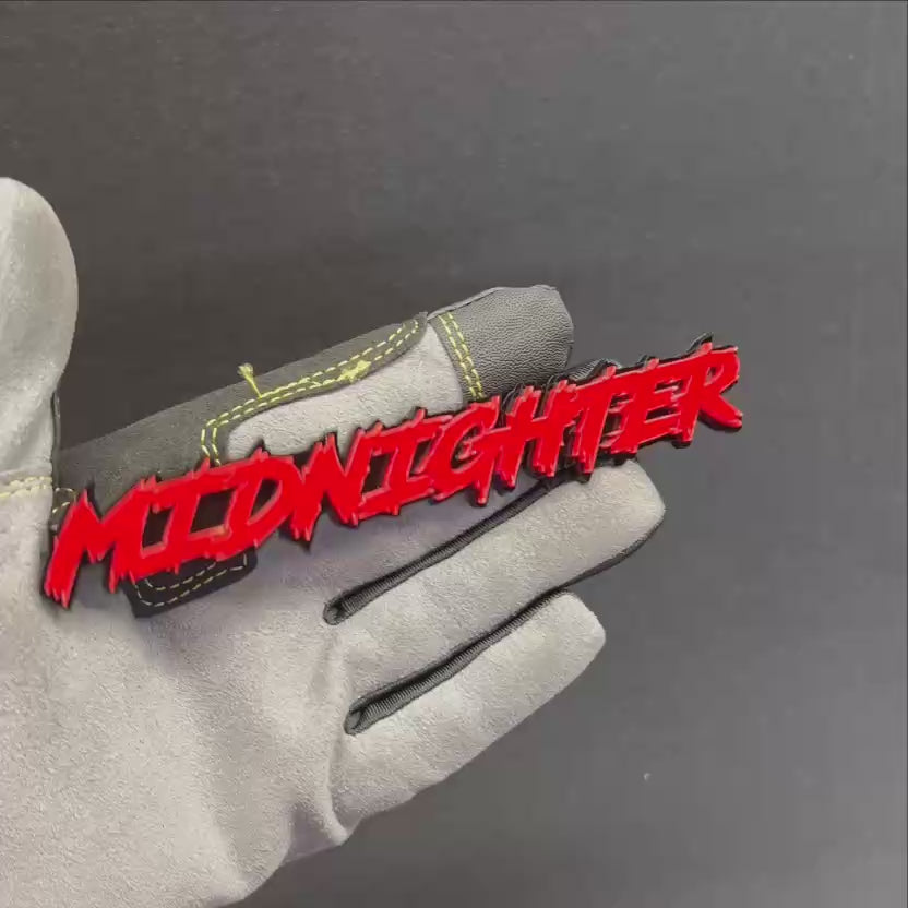 Midnighter car badge with red top layer and black base