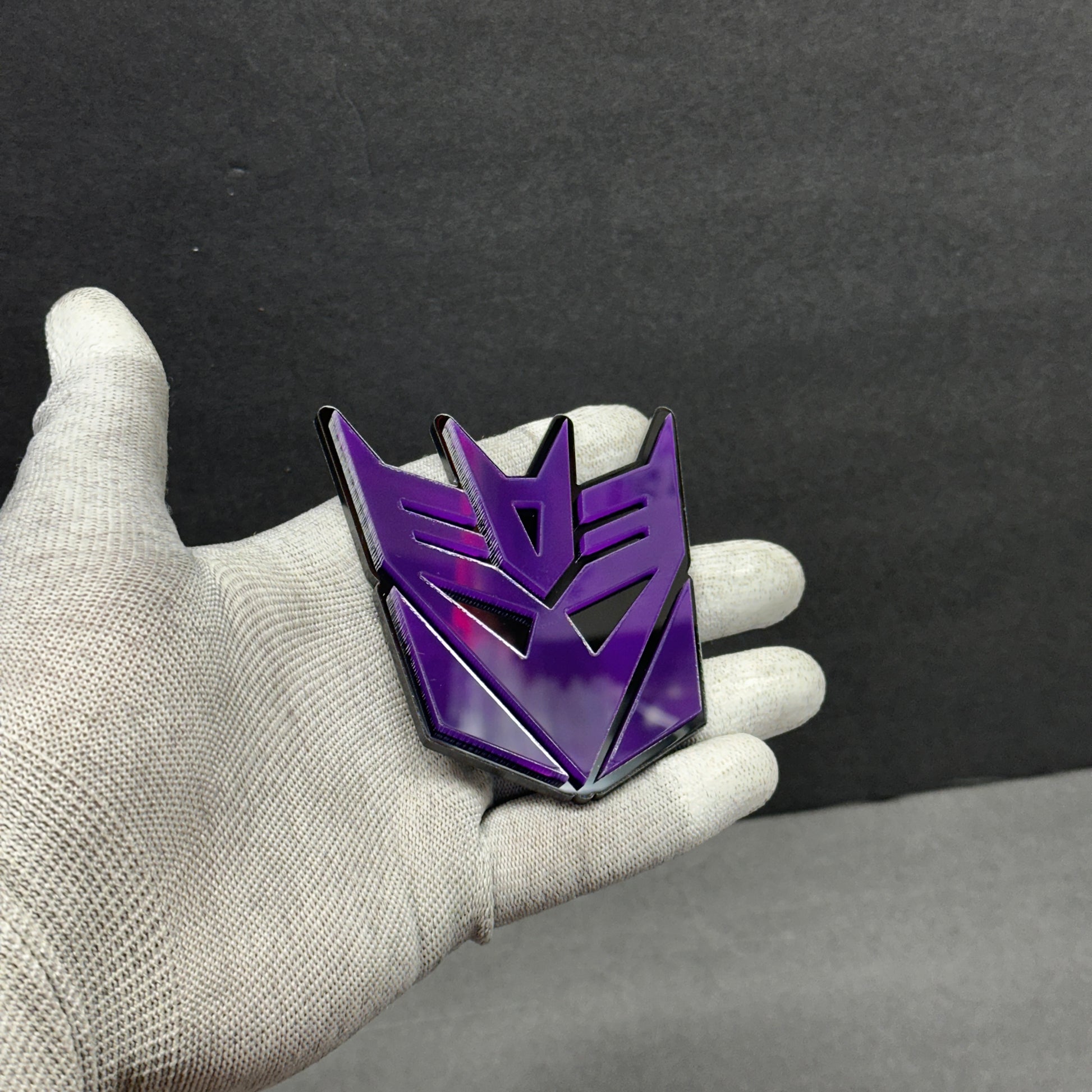 Back of purple Decepticon car emblem with automotive 3M adhesive peel-and-stick backing