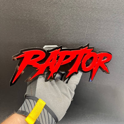 Layered RAPTOR text badge with sharp lettering on a black hitch cover