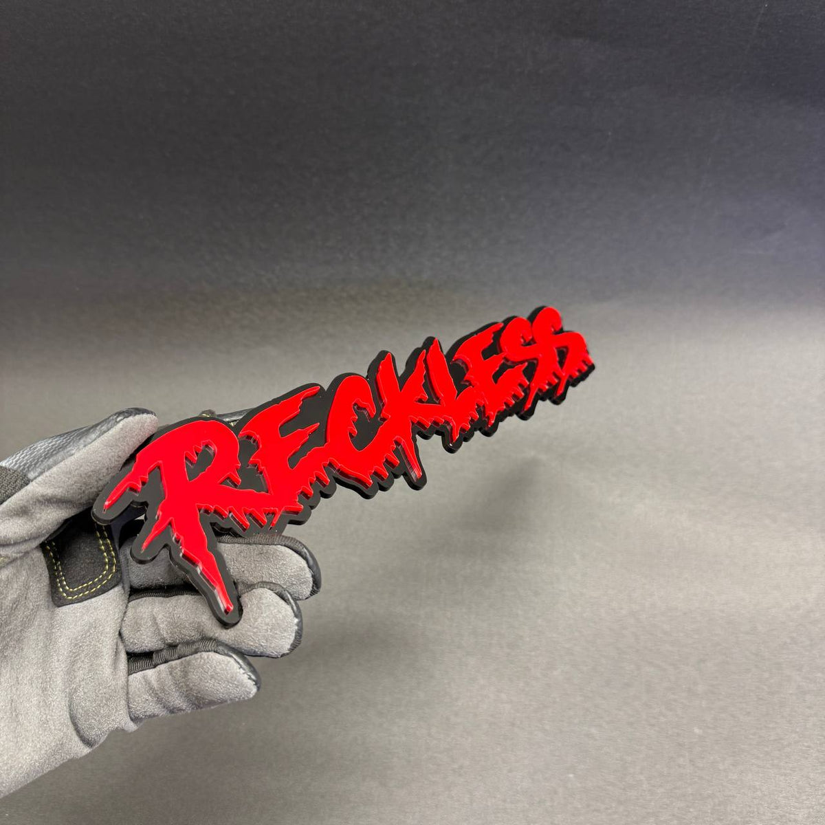 Reckless aggressive street racing style emblem with red lettering and black outline for Jeep Wrangler Gladiator custom exterior.