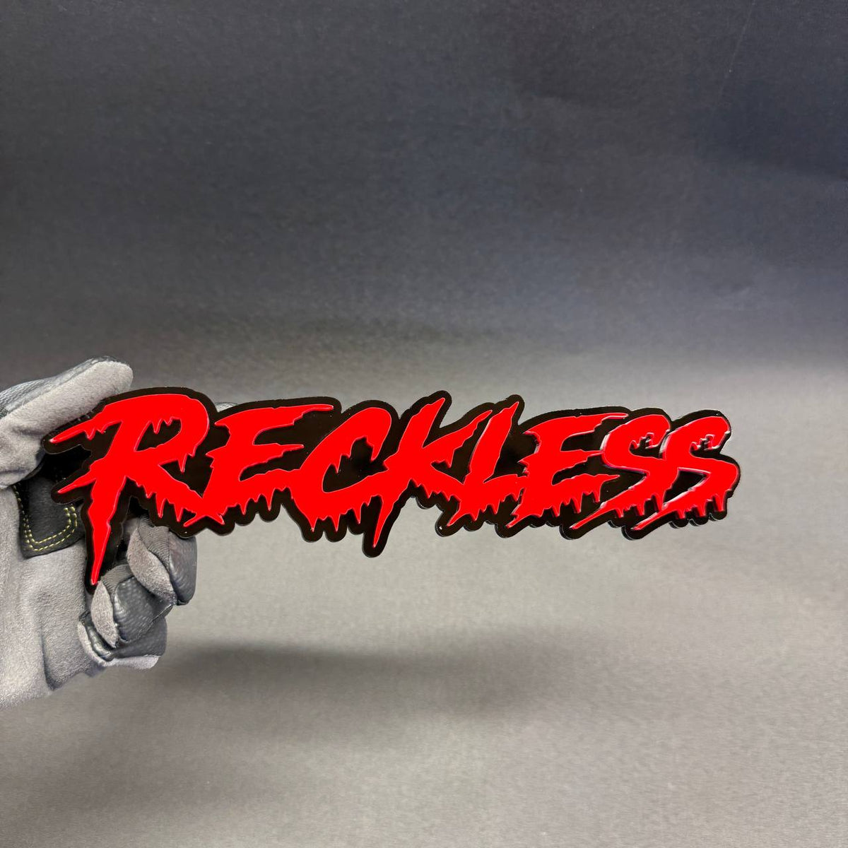 Custom Reckless horror lettering car emblem with aggressive red and black layered design for Ford Mustang GT Shelby.