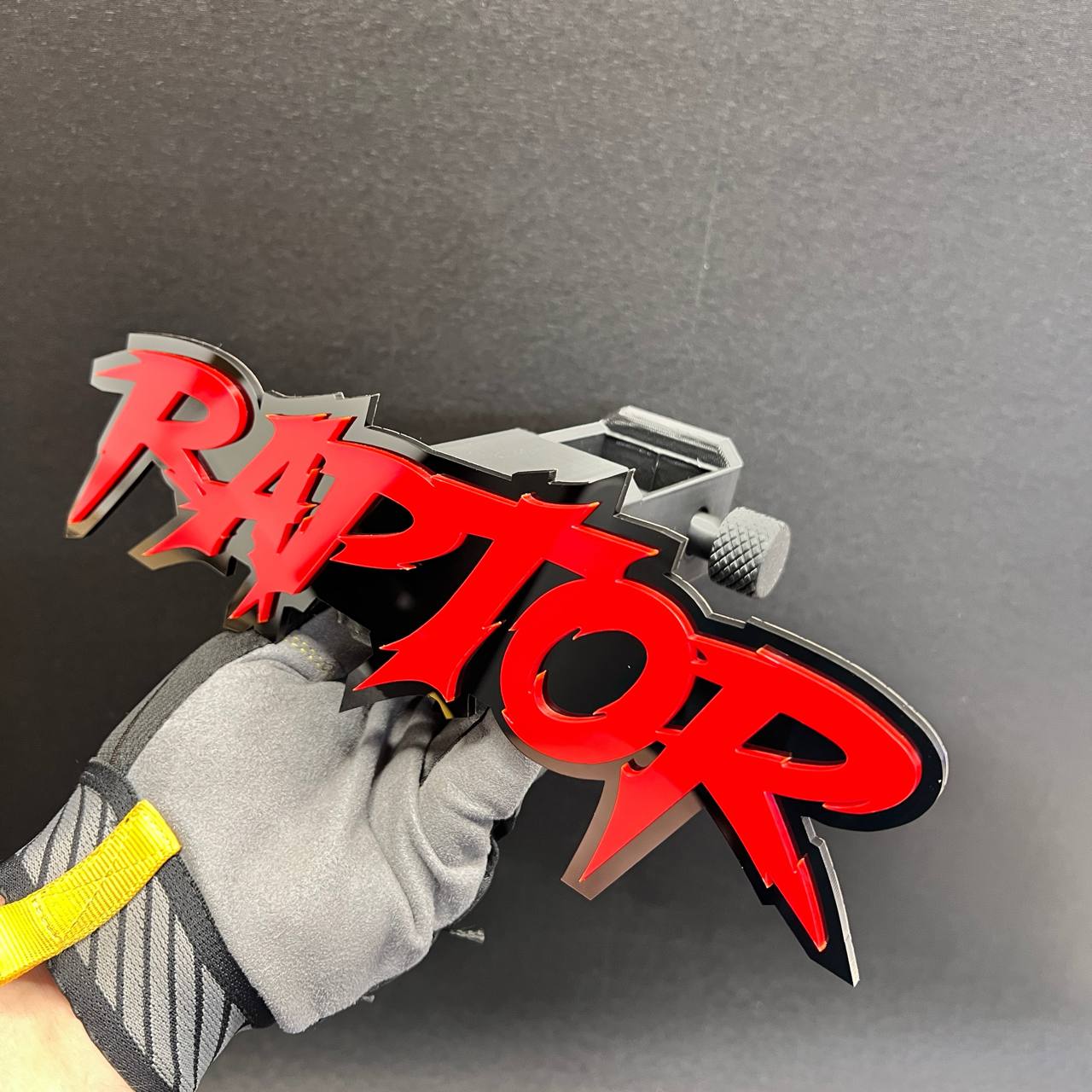 Red RAPTOR truck hitch cover badge with glossy layered construction