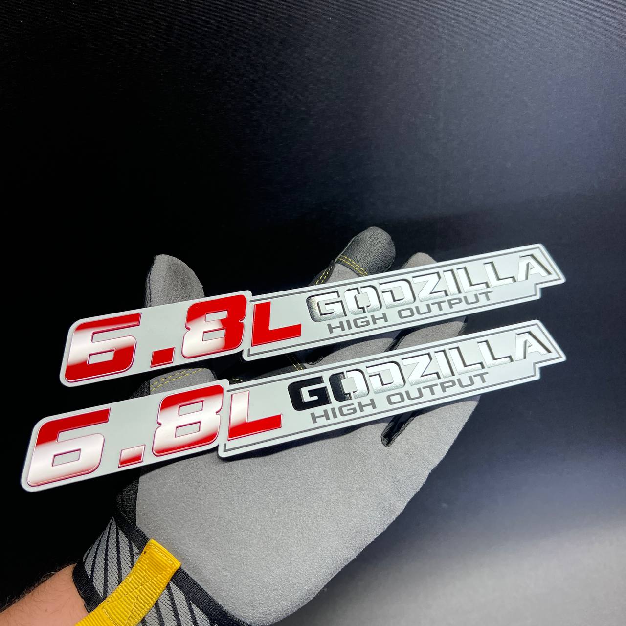 Red and silver 6.8L Godzilla High Output fender badge with black lettering